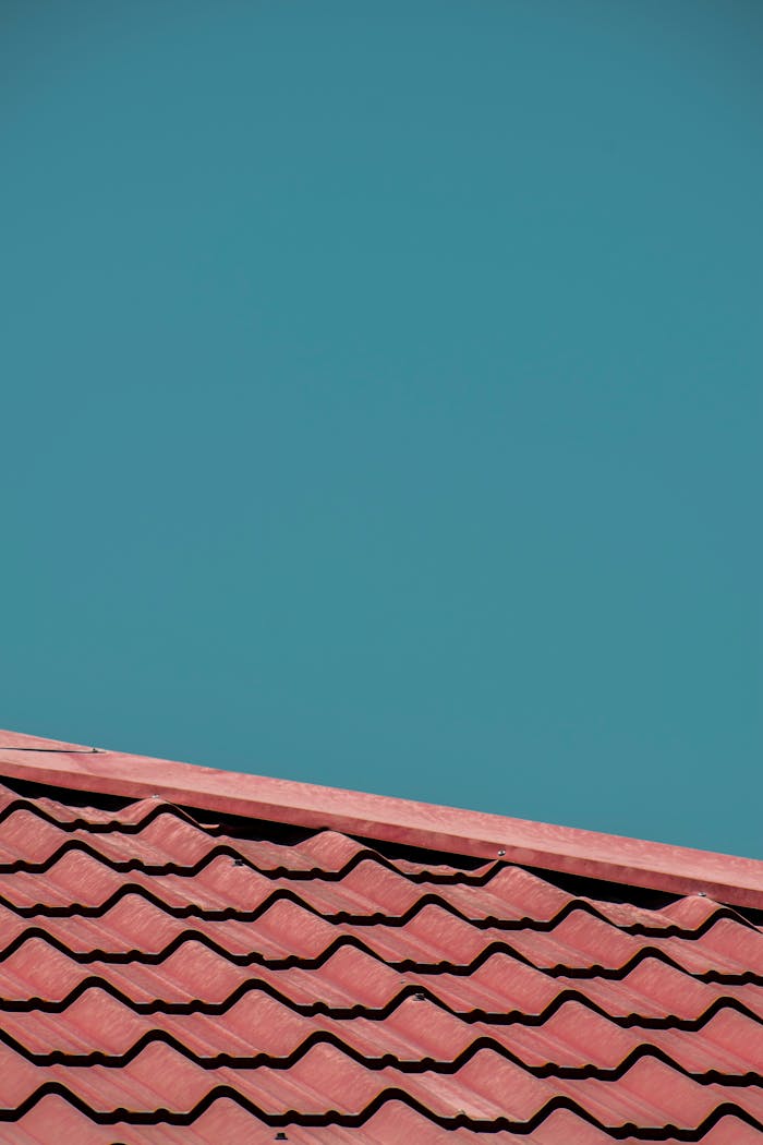 Close-up of red roof tiles with a clear blue sky background, offering ample copy space.