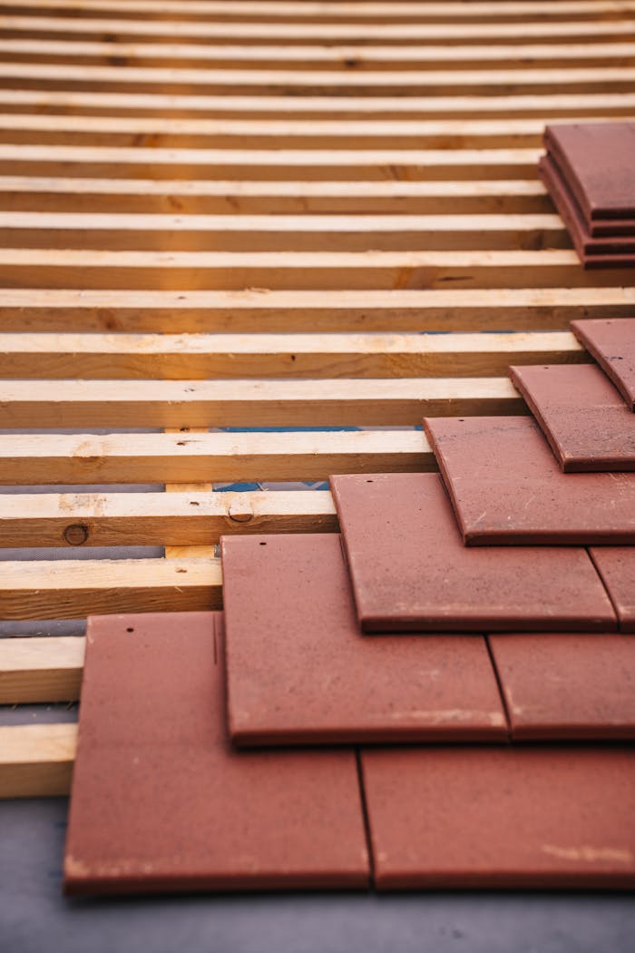 journey Red roofing tiles and wooden framework in progress on a building roof.