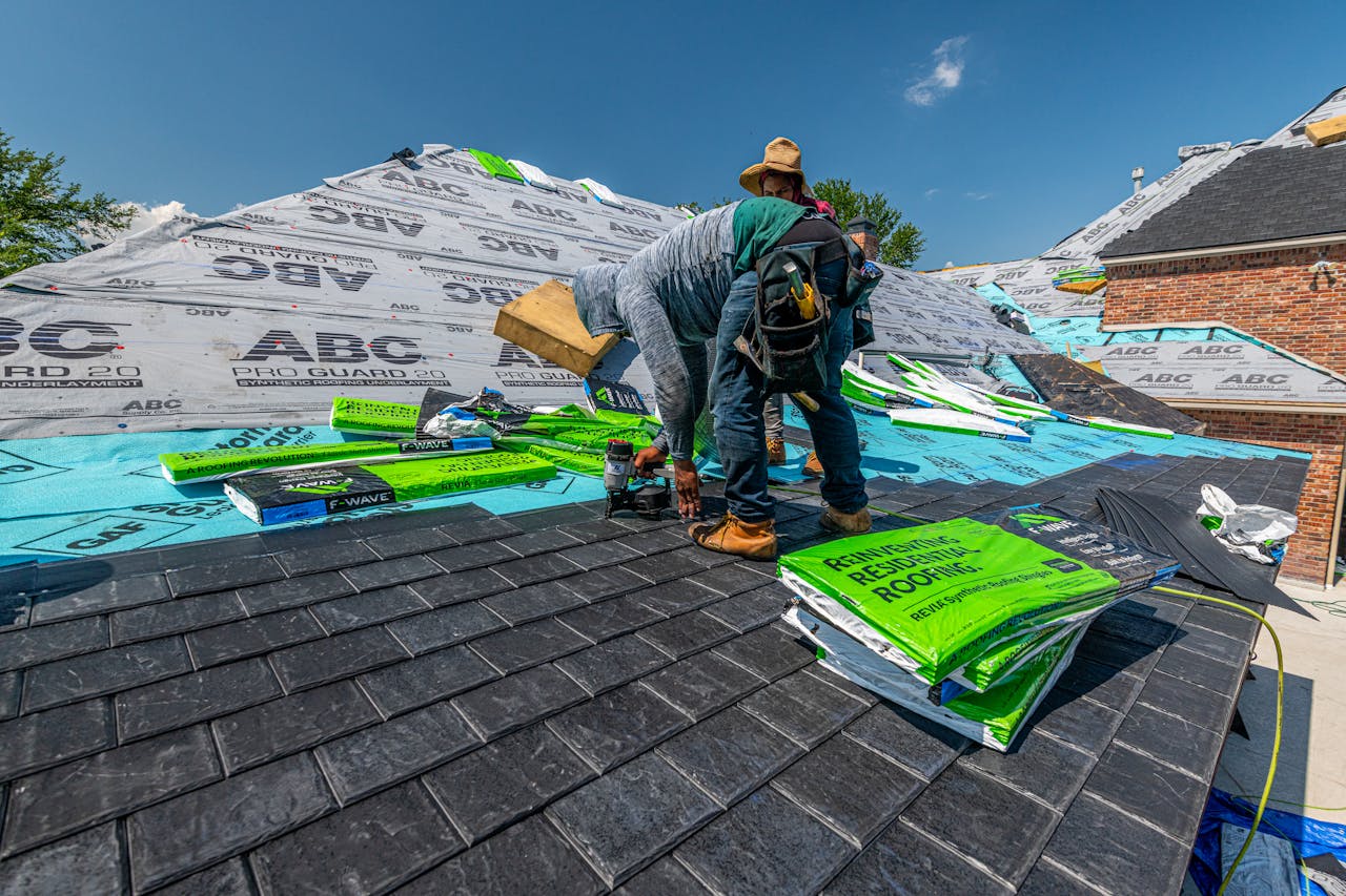 services-04 Workers installing a synthetic slate roof on a brick house in Fort Worth, Texas.